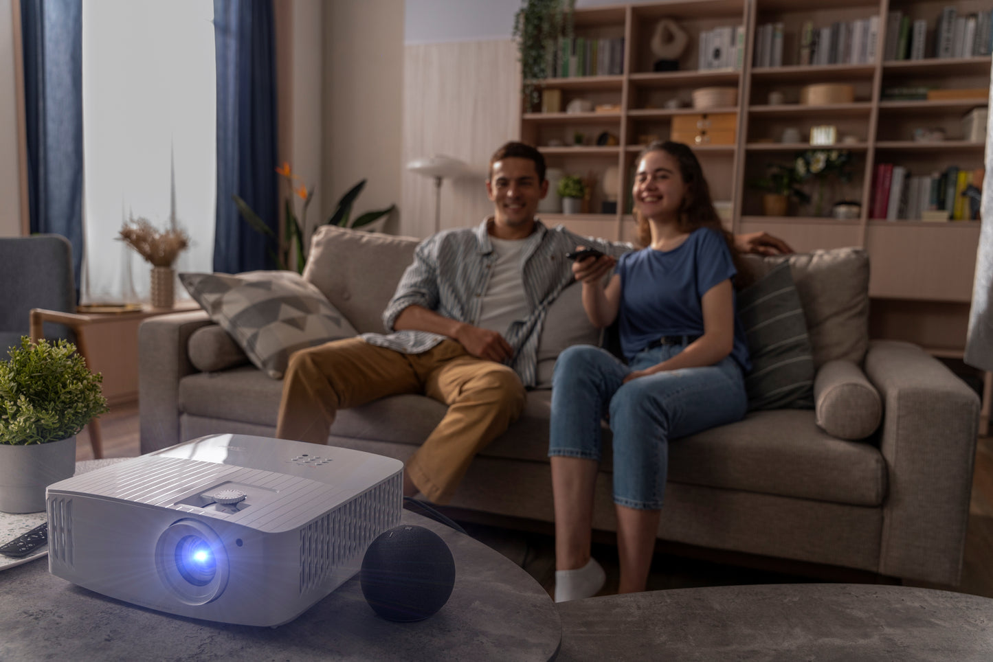 UHD55 Beamer im Wohnzimmer aufgestellt beim Heimkino schauen bei Tageslicht